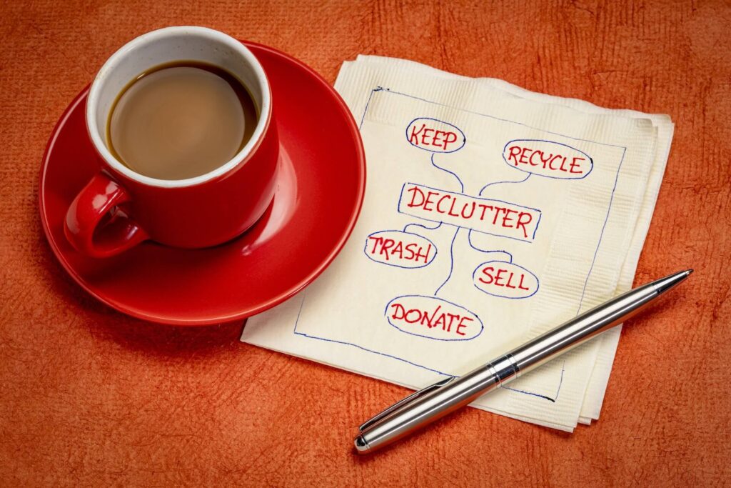 Coffee next to a pen and a napkin with a decluttering plan written on