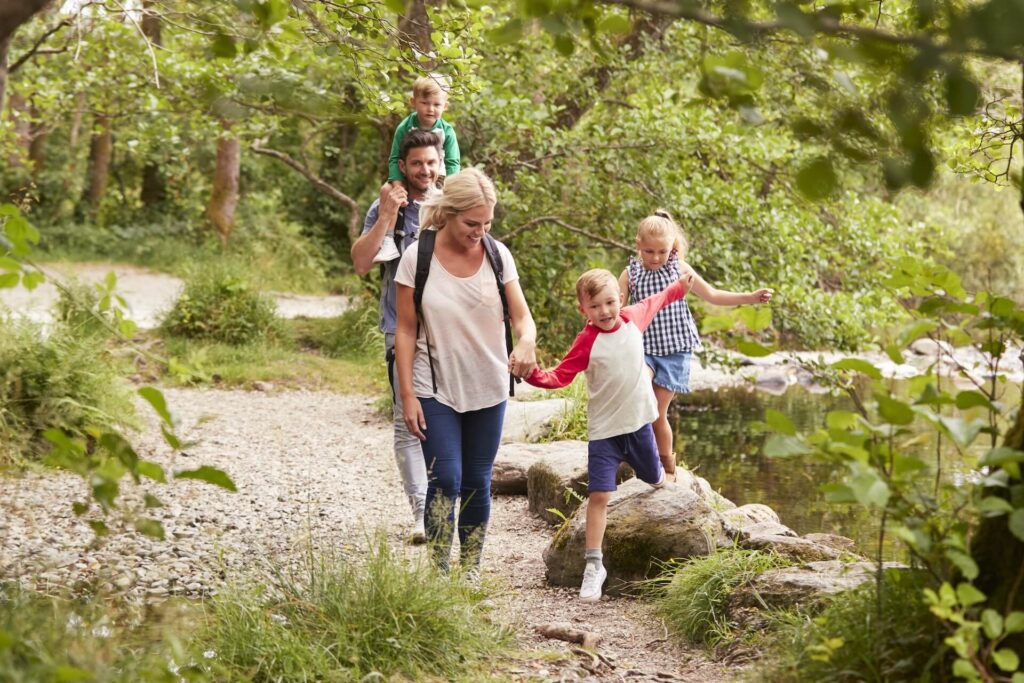 A family with kids going hiking and smiling