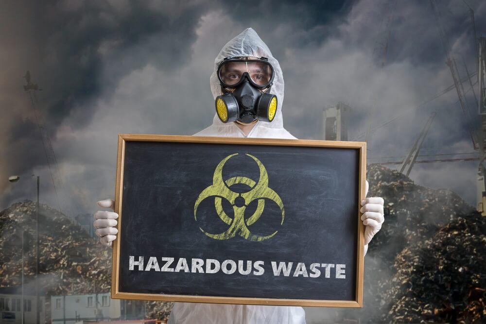 A person in a hazmat suit holding a sign that says Disposable waist