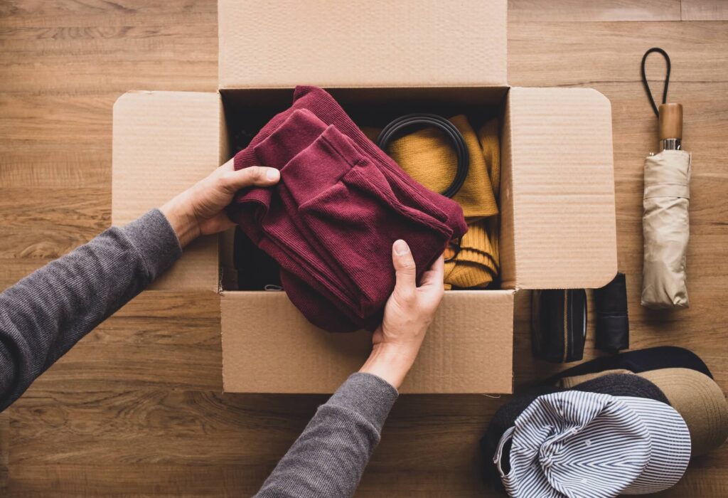 A person placing clothes in a box