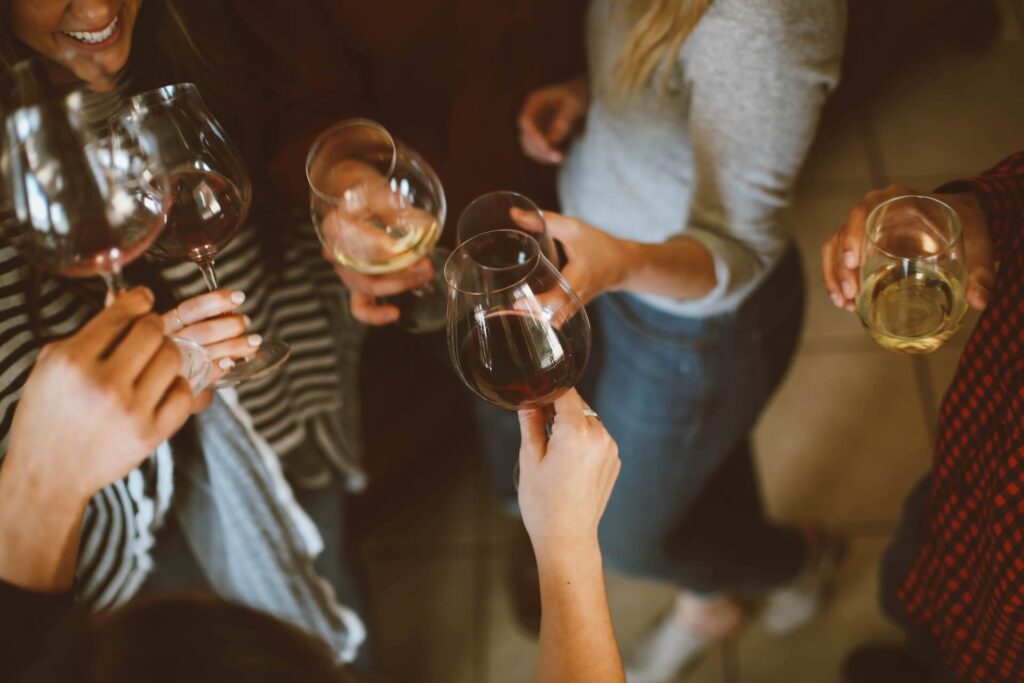 Groups of five at the party, cheering with wine glasses