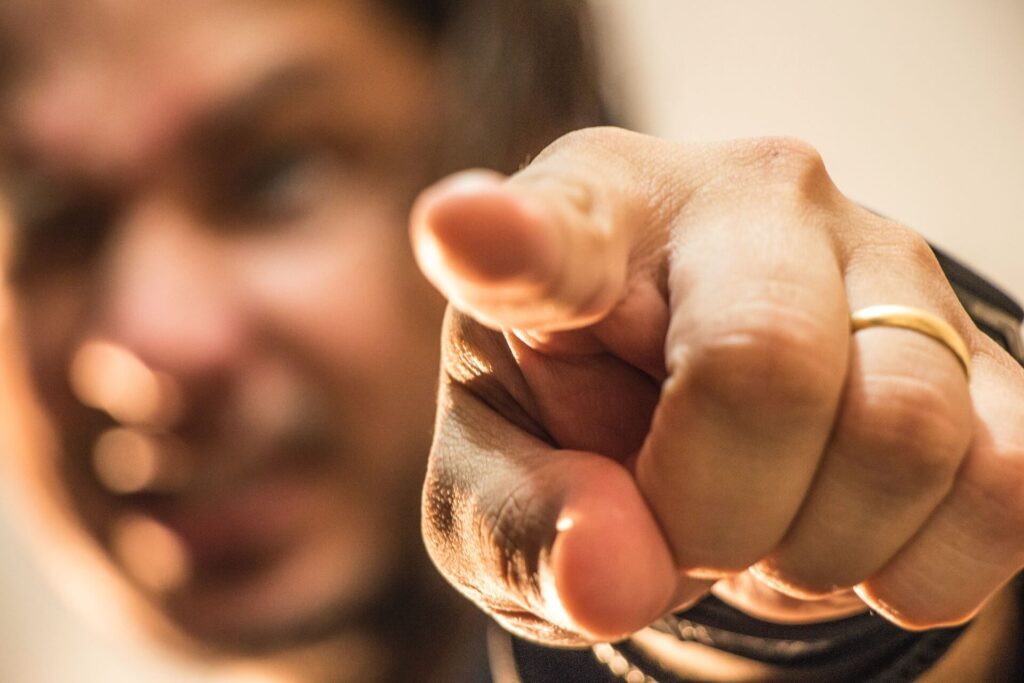 A man pointing his left index finger up close