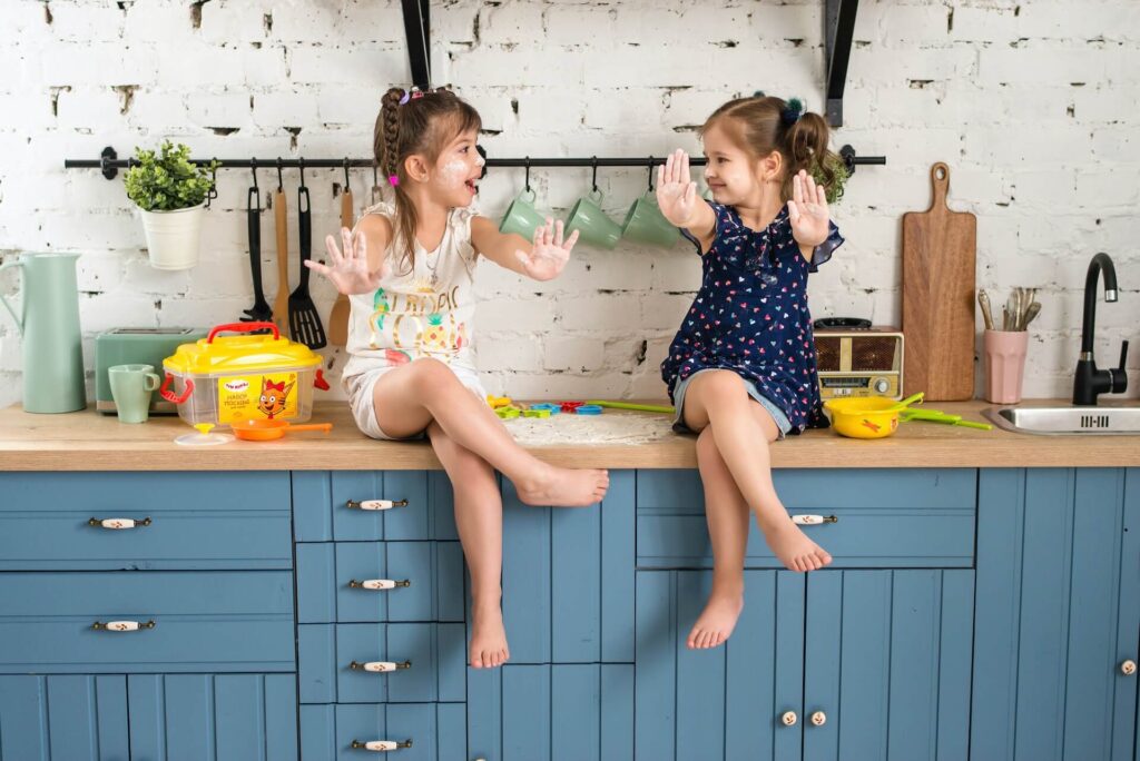 Two girls sitting on a kitchen counter