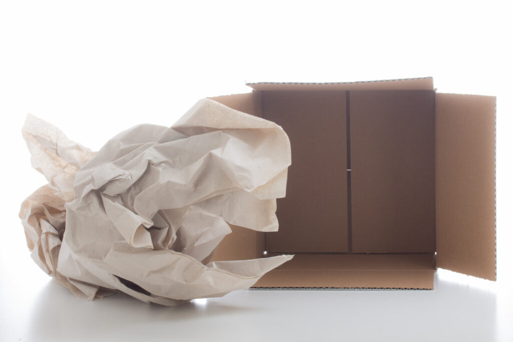 Clumbled packing paper next to a moving box